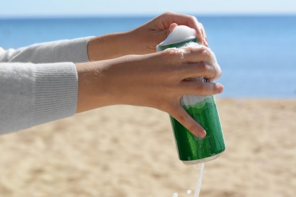 Woman,Opening,Can,With,Sparkling,Drink,At,Beach,,Closeup